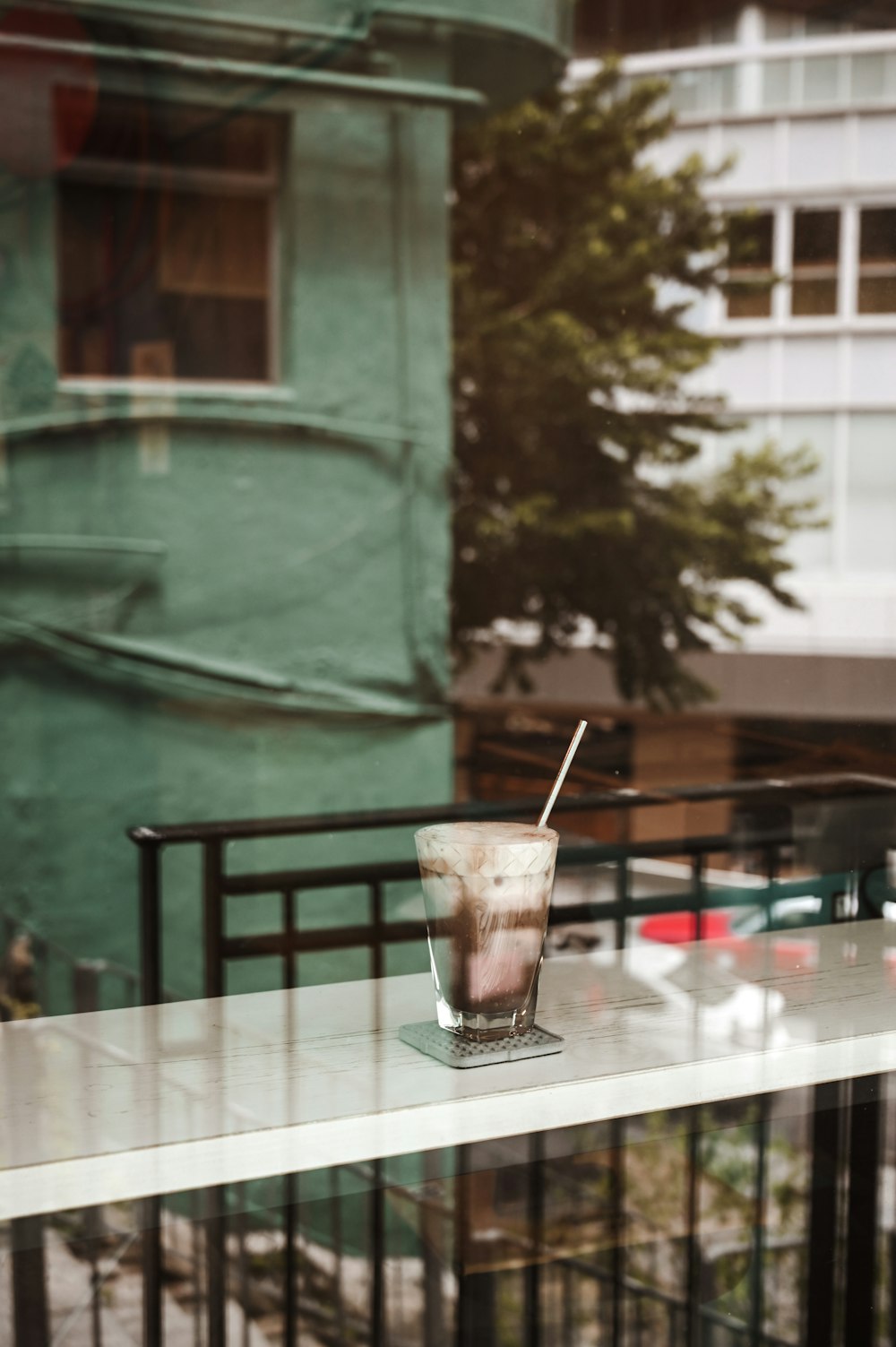 clear drinking glass with brown liquid on table