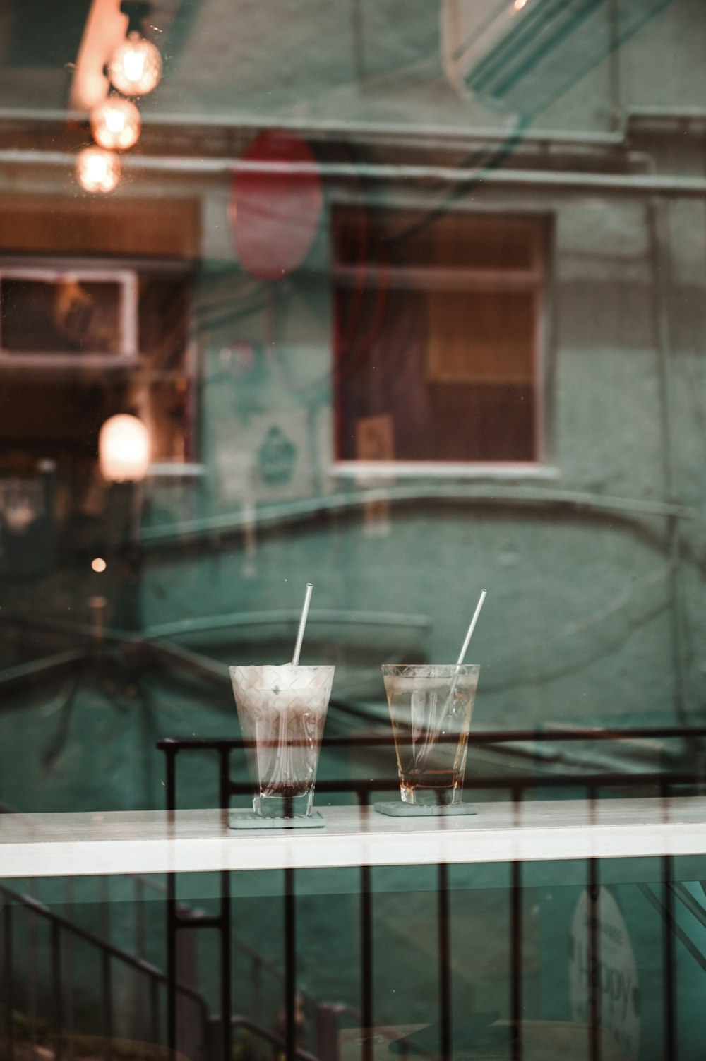 two clear plastic disposable cups with straws on table