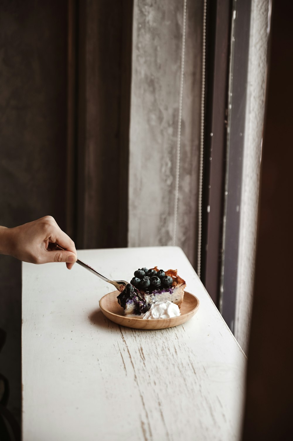 person holding spoon with black berries on it