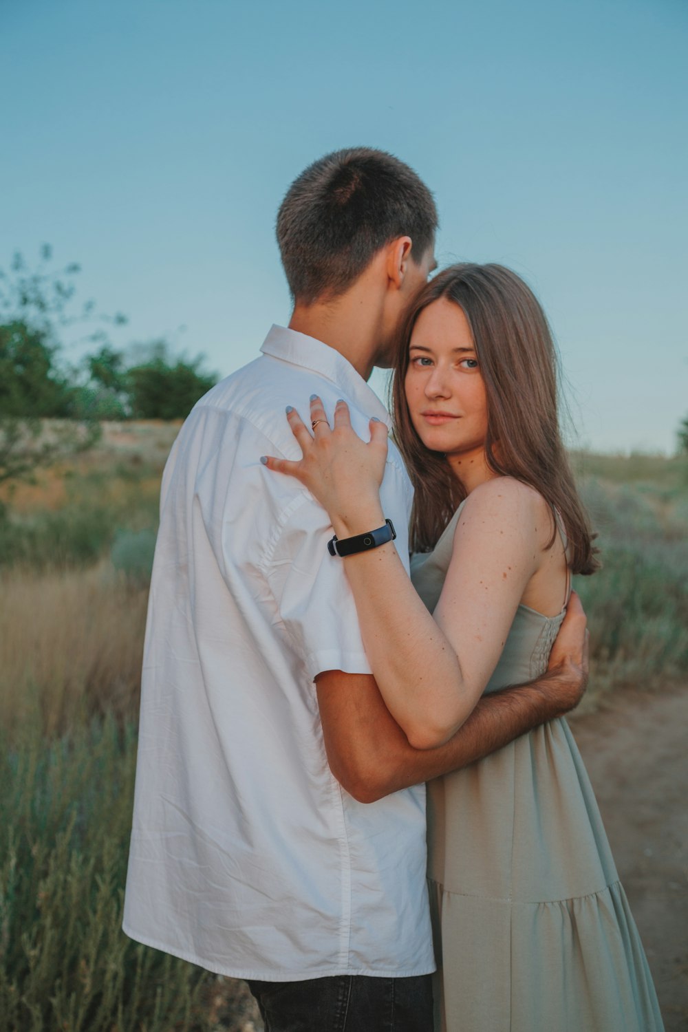 man in white shirt kissing woman in white dress