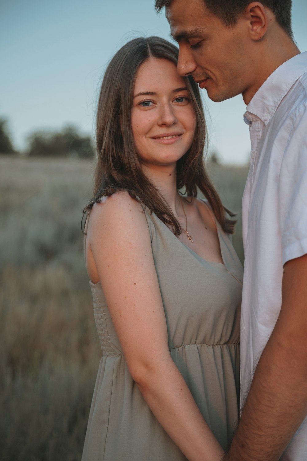 woman in white dress beside man in white dress shirt