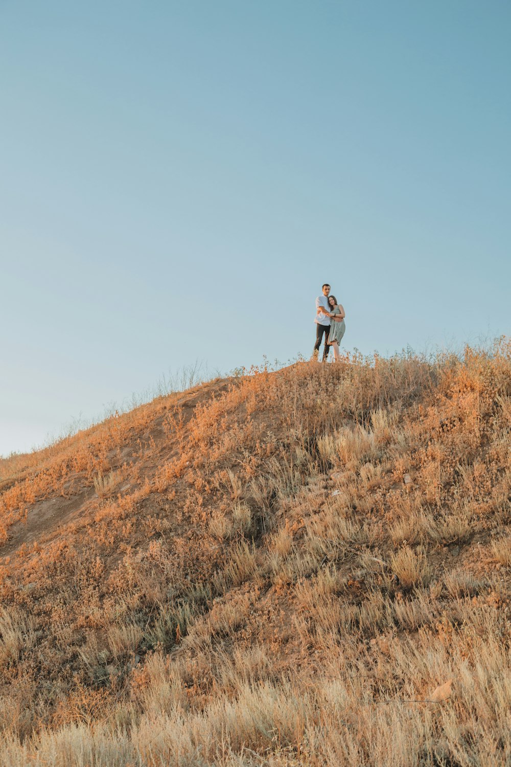 man in black jacket walking on brown grass field during daytime