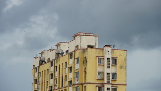 yellow and brown concrete building under blue sky during daytime in Rajkot India