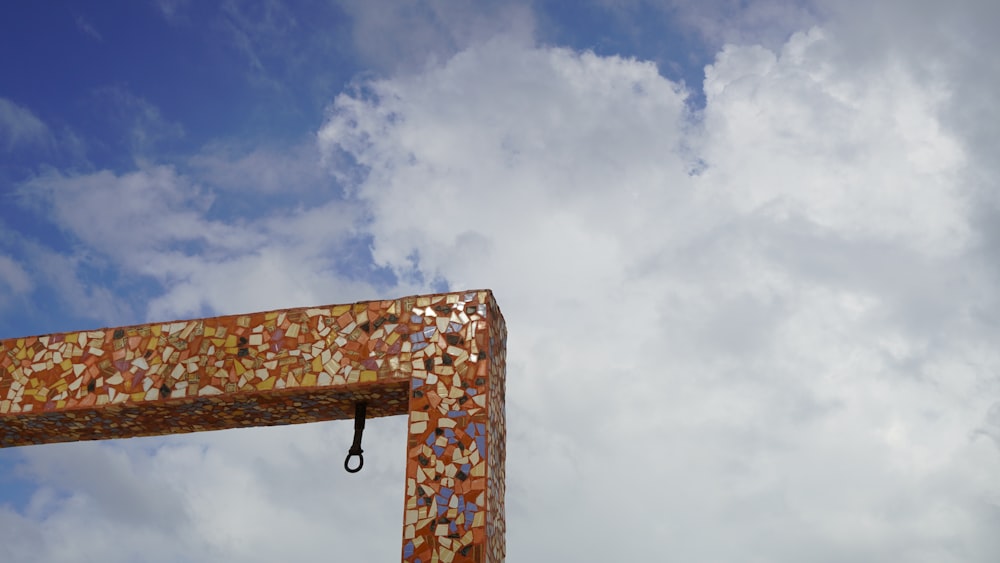 brown wooden cross under white clouds during daytime