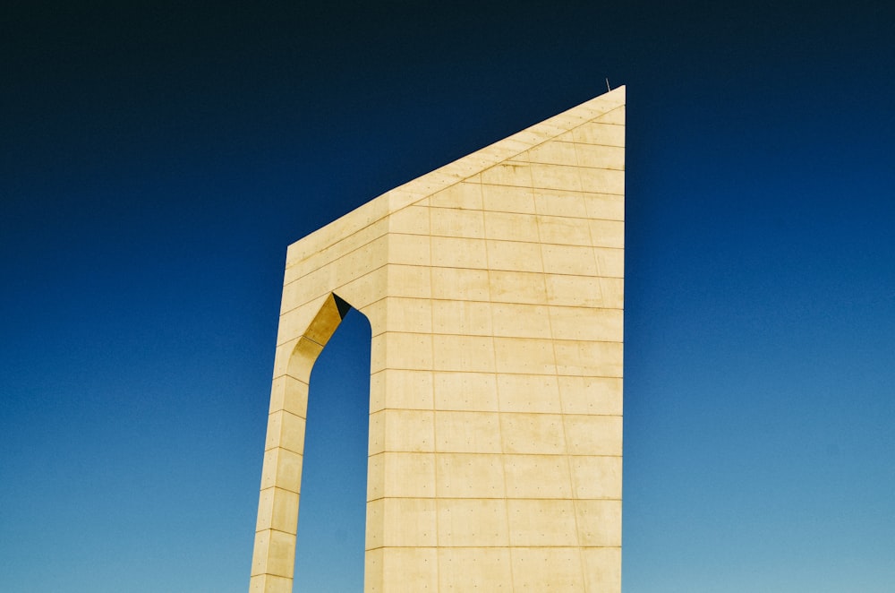 Weißes Betongebäude unter blauem Himmel tagsüber