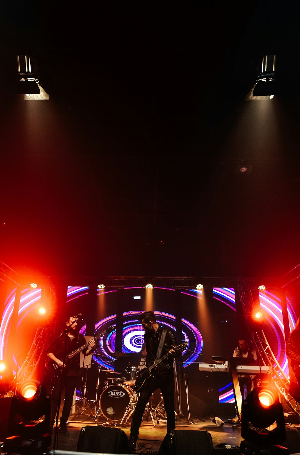 people standing on stage with lights turned on during nighttime