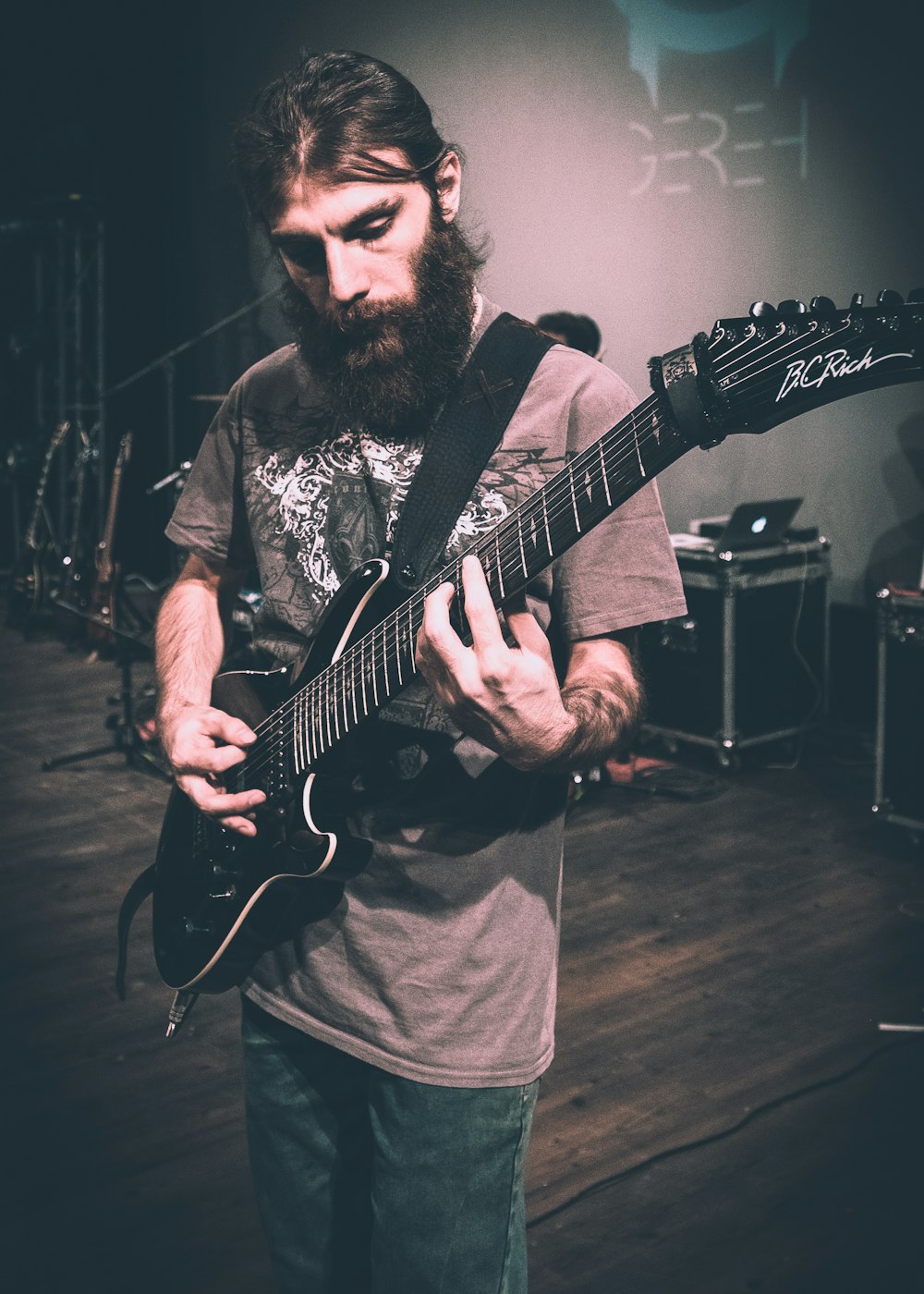 man in gray crew neck shirt playing electric guitar