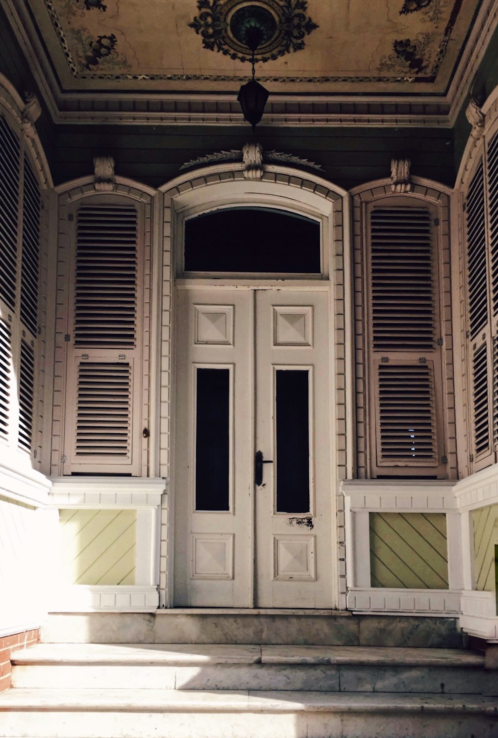 brown wooden door on white concrete building