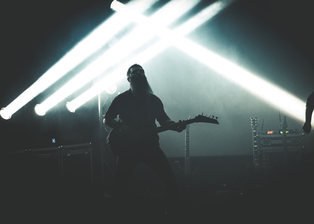 man playing guitar on stage