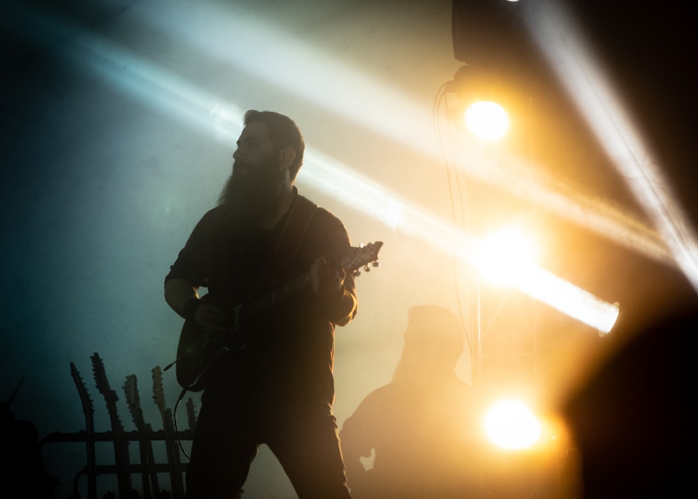 man playing guitar on stage