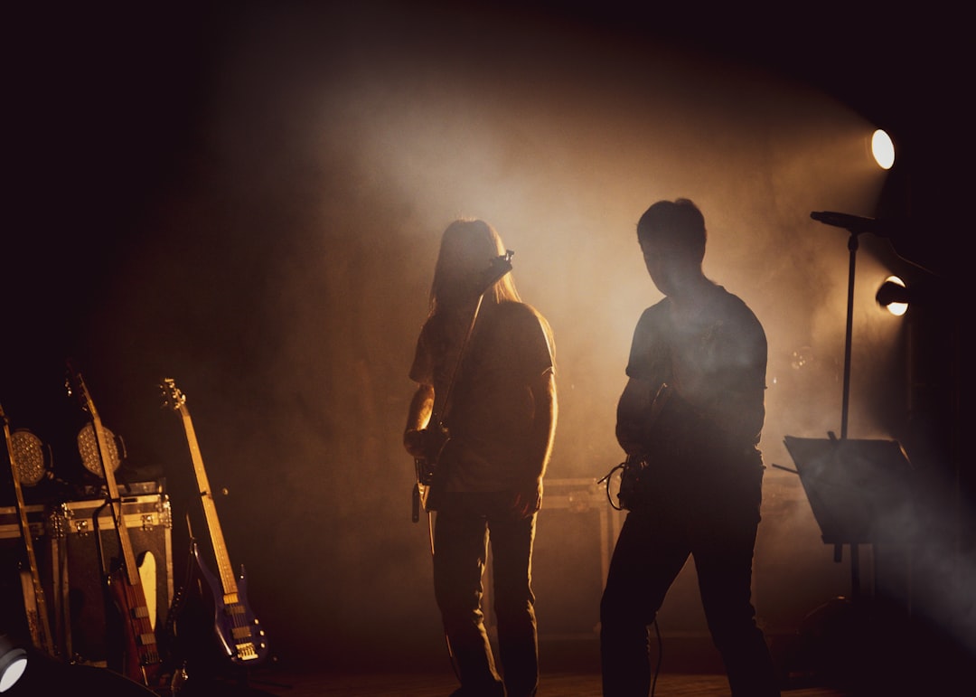 silhouette of 3 men standing on stage