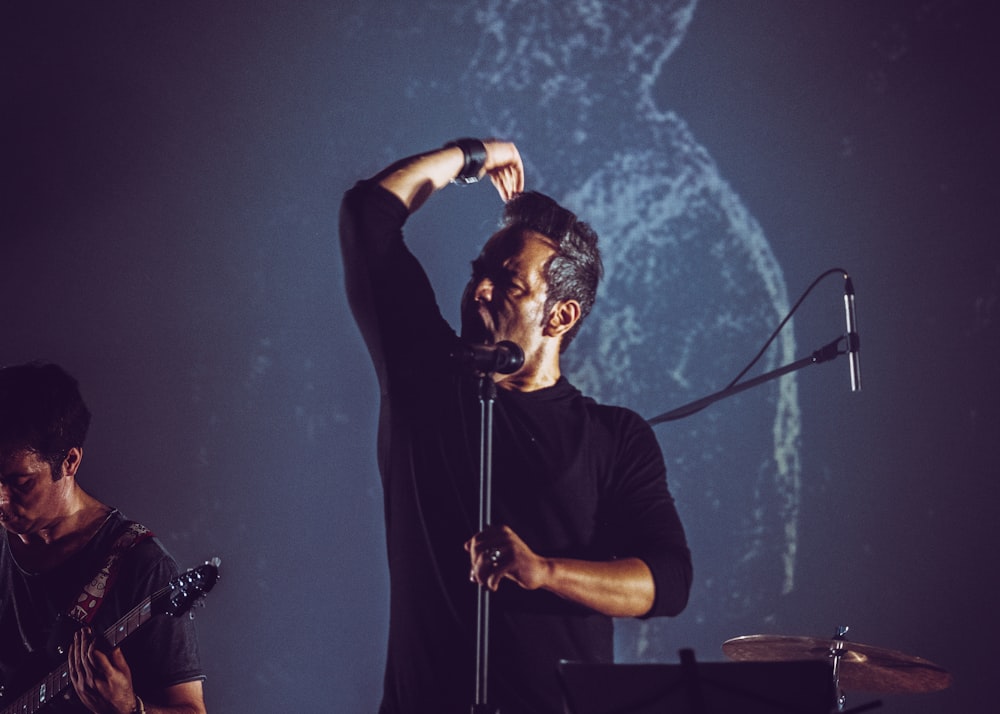 man in black crew neck t-shirt singing