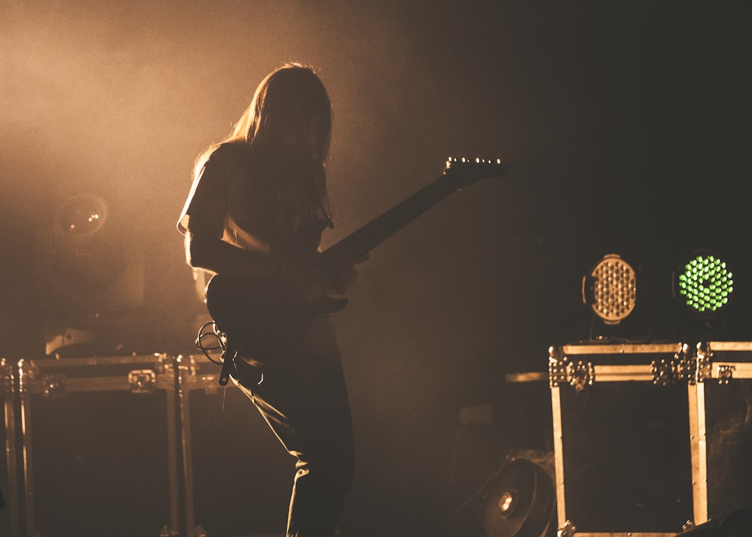 woman playing guitar on stage