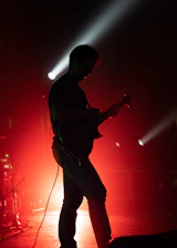 Portrait of Lorenzo Guerrieri performing on stage with dramatic lighting and elegant dark background.