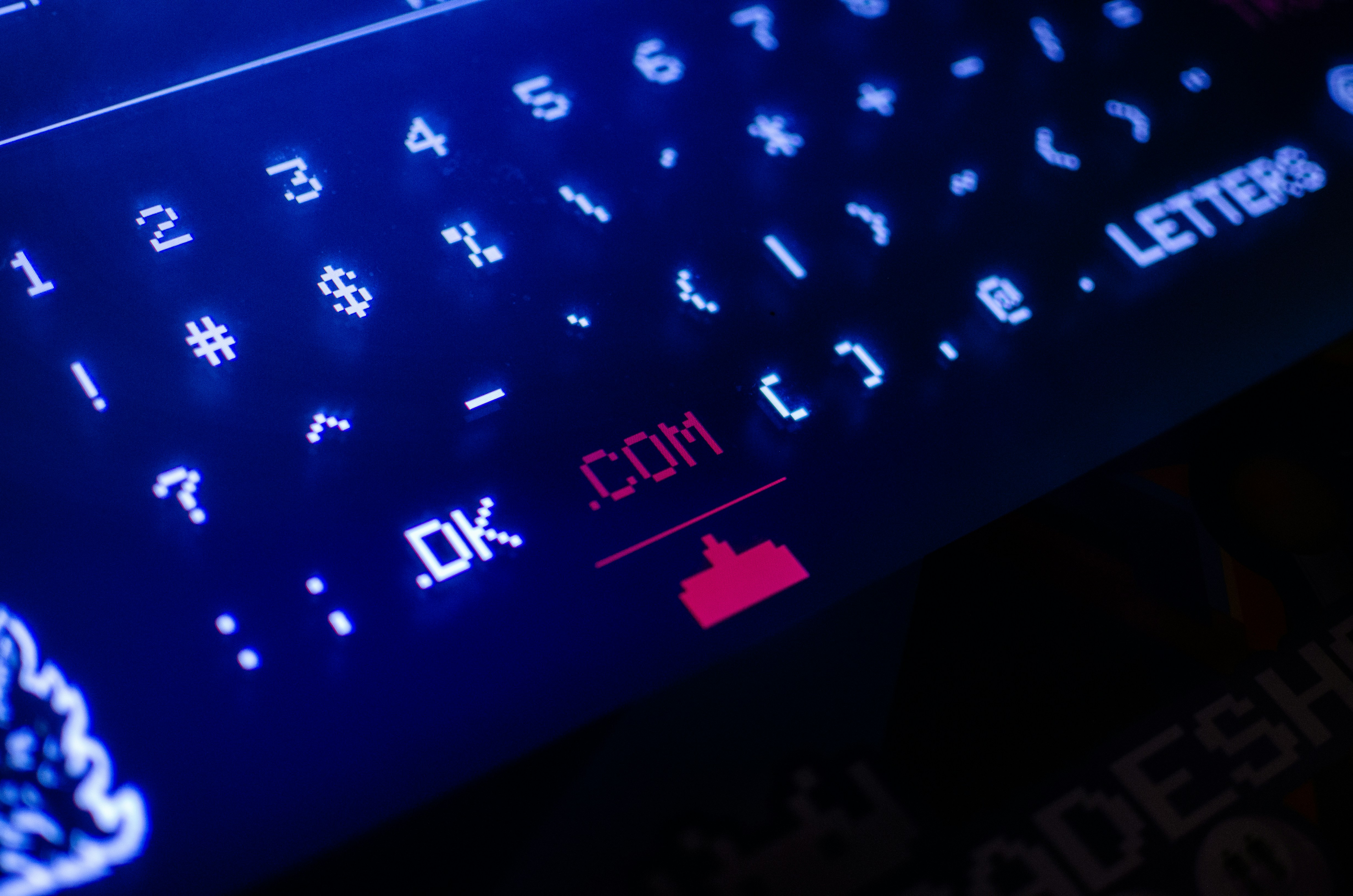 black and blue computer keyboard highlighting a .com which is a top level domain.