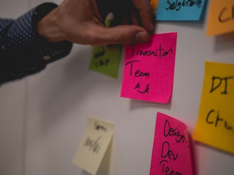 person holding pink sticky note