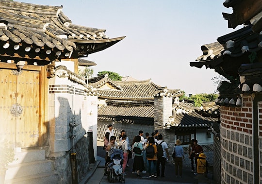people walking on street during daytime in Bukchon Hanok Village South Korea