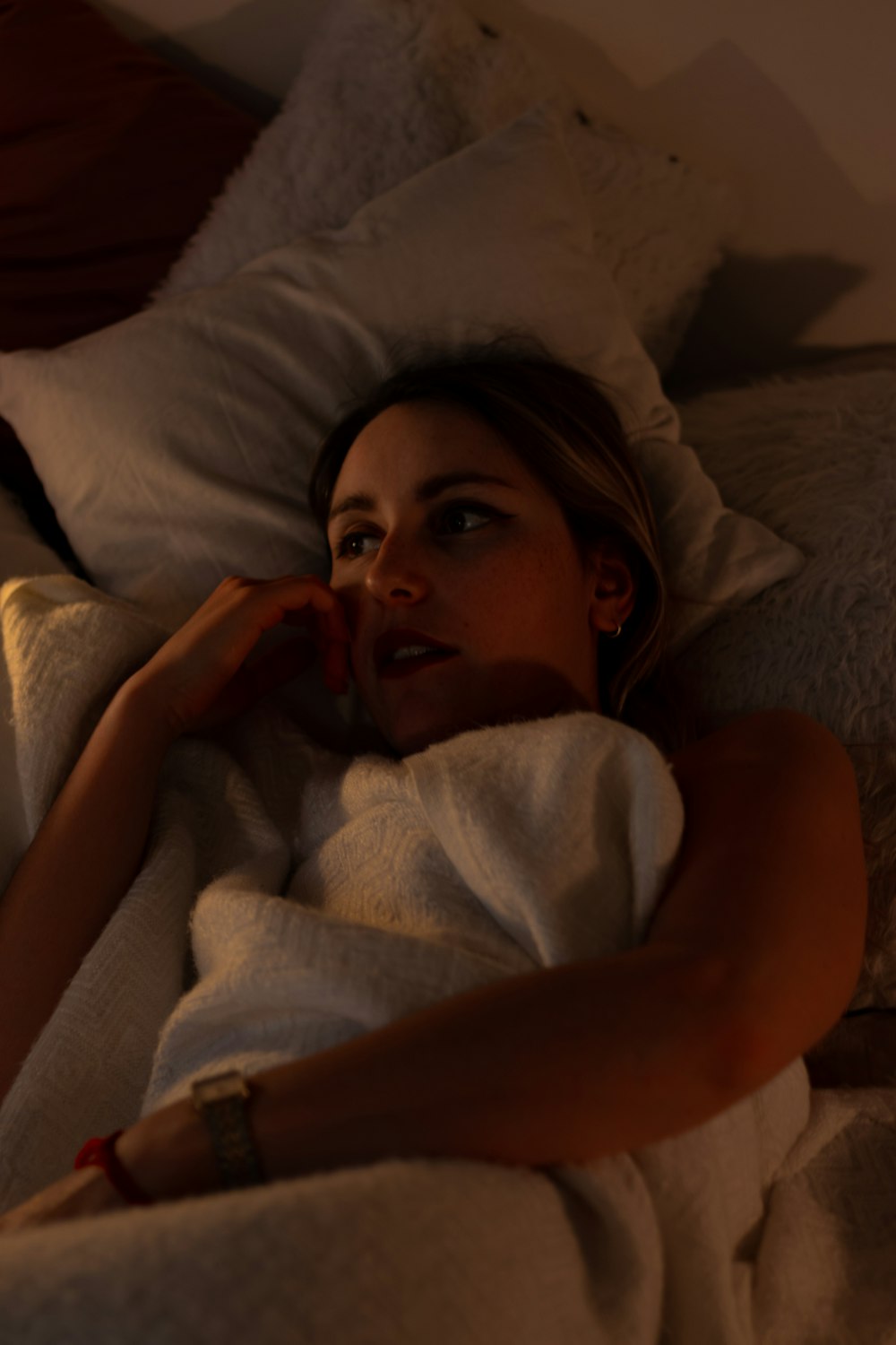 girl lying on bed covered with blanket