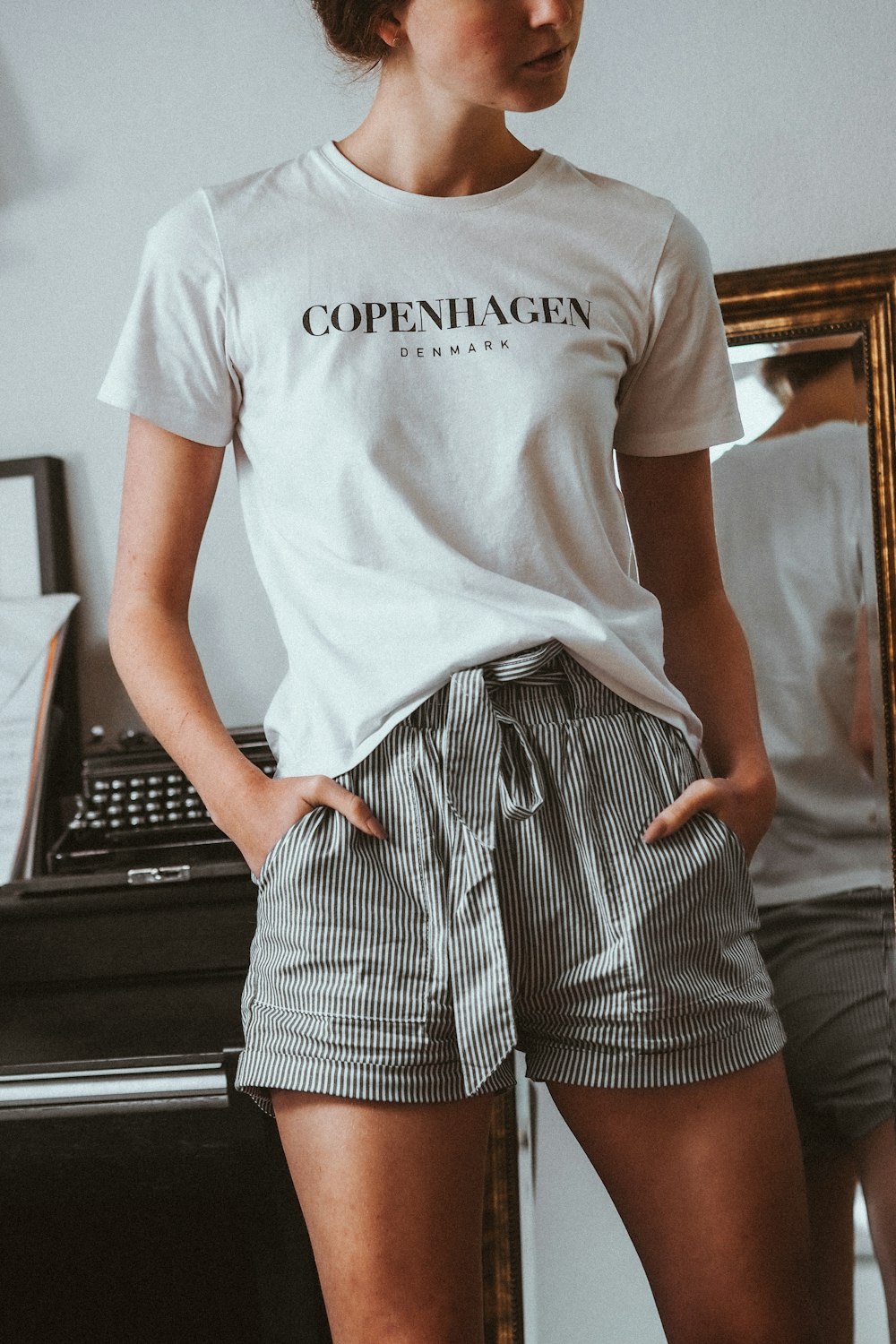 woman in white crew neck t-shirt and black and white striped skirt