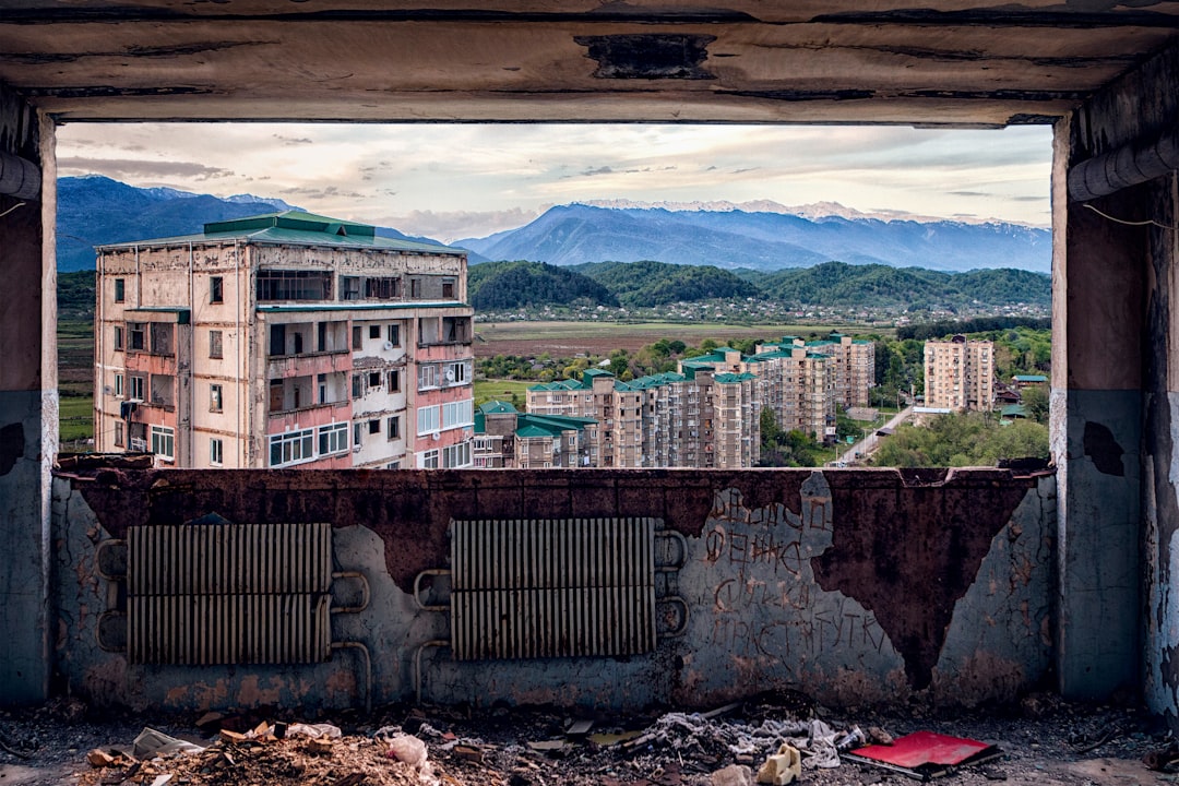 brown concrete building near mountain under blue sky during daytime