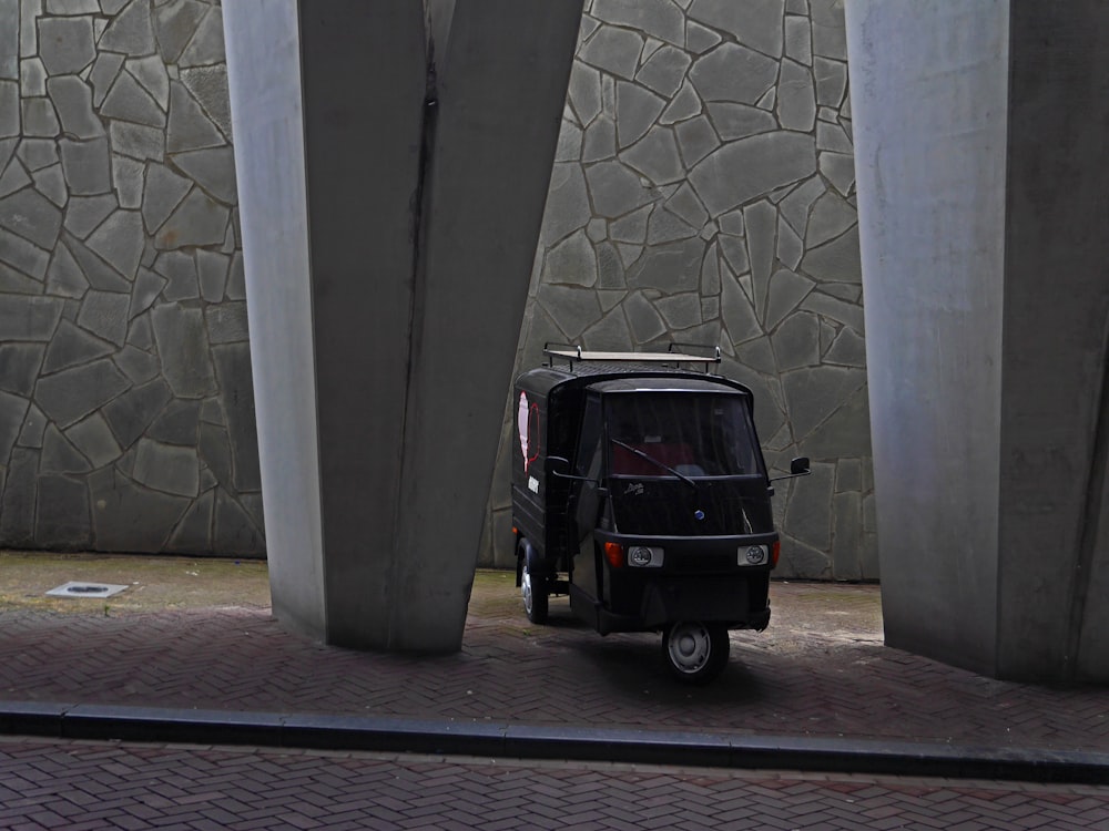 black suv parked beside gray concrete wall