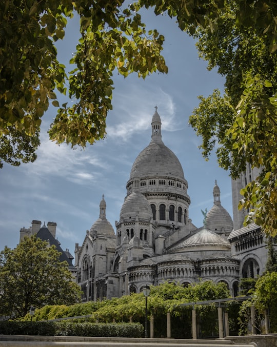 white and gray concrete building under blue sky during daytime in Basilique du Sacré-Cœur France