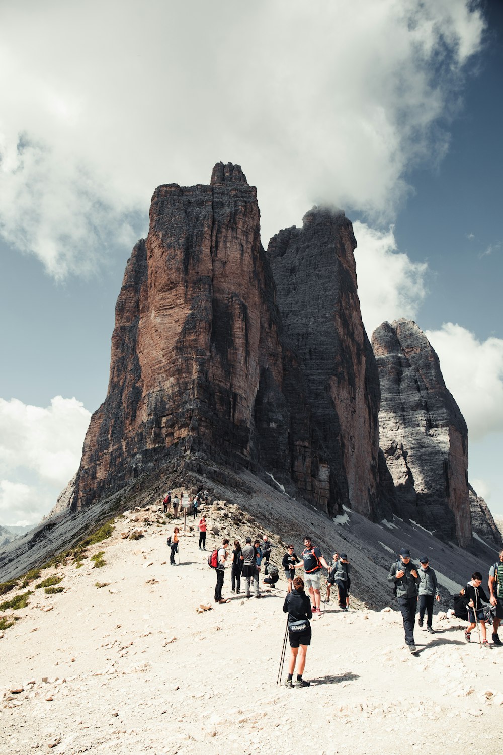 people walking on white sand near brown rock formation during daytime