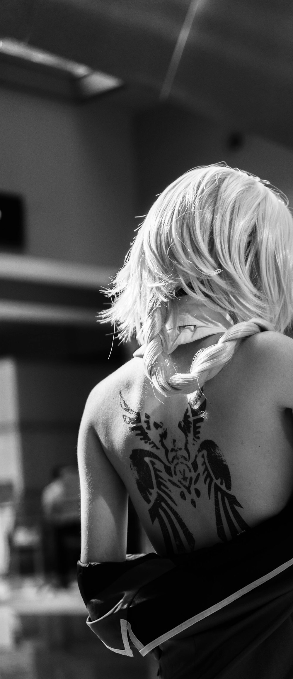grayscale photo of woman with floral tattoo on her back
