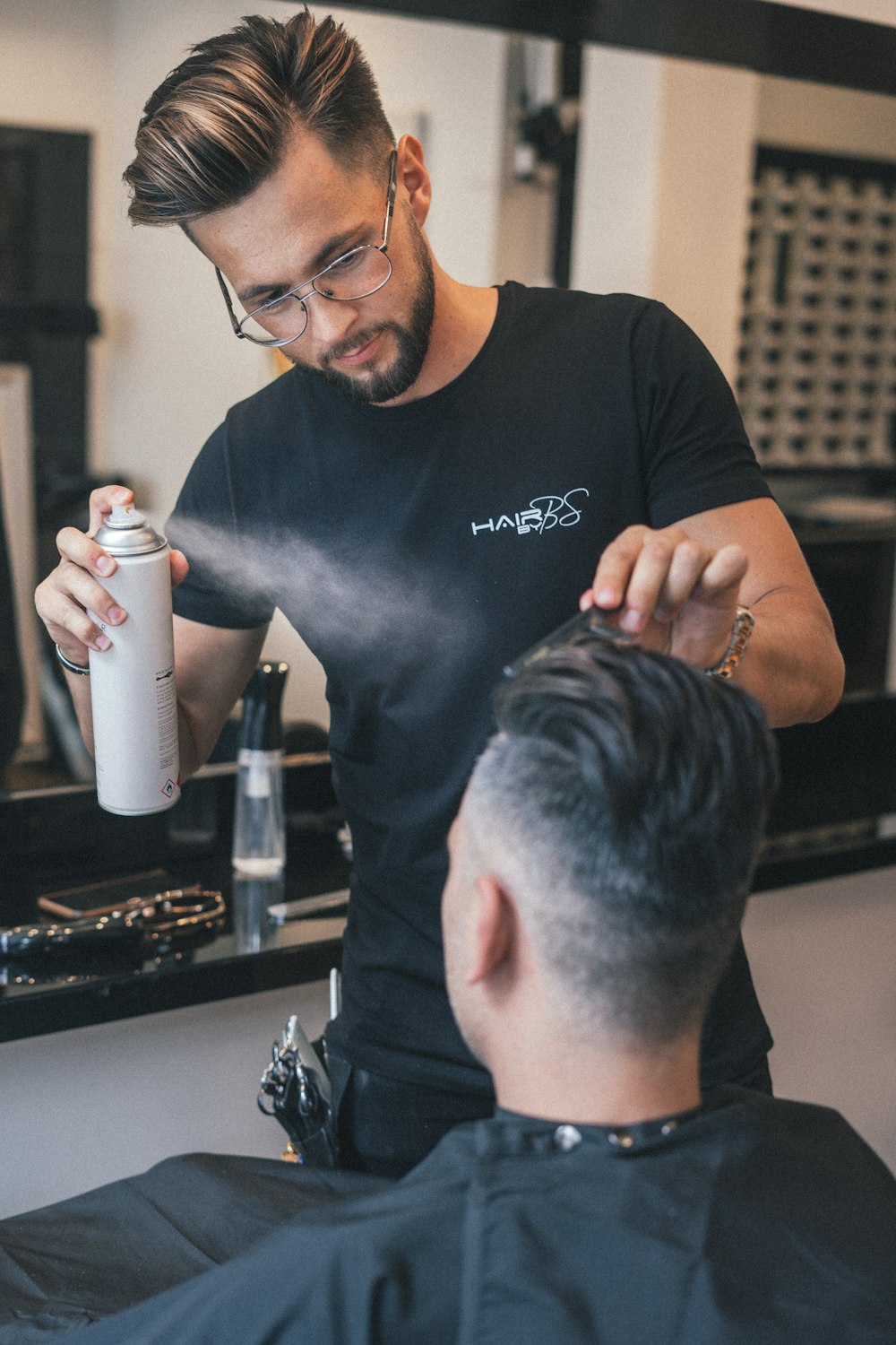 man in black crew neck t-shirt holding white bottle