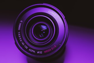 Close-up of a cinematic camera lens glowing with purple and electric green neon lights.