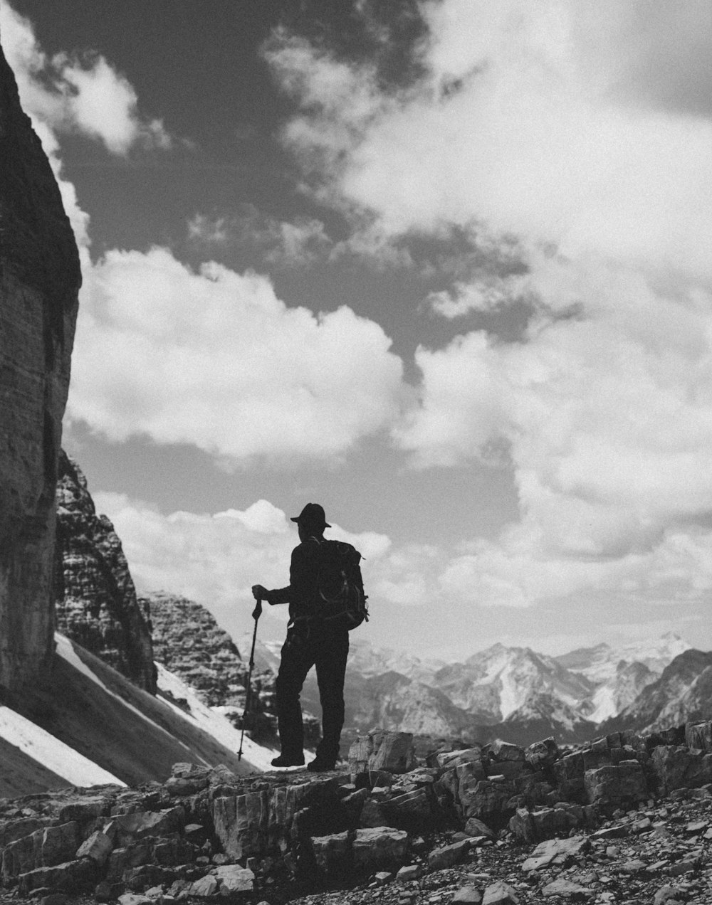 man in black jacket and pants standing on top of a mountain