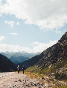 person walking on road near mountains during daytime