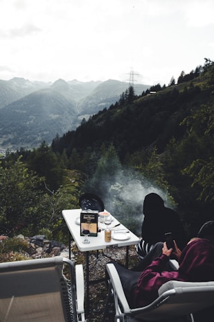 Guests enjoying a hearty traditional meal outdoors with mountain views in the background.
