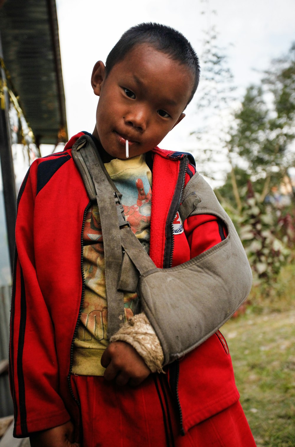 boy in brown and red jacket with red backpack