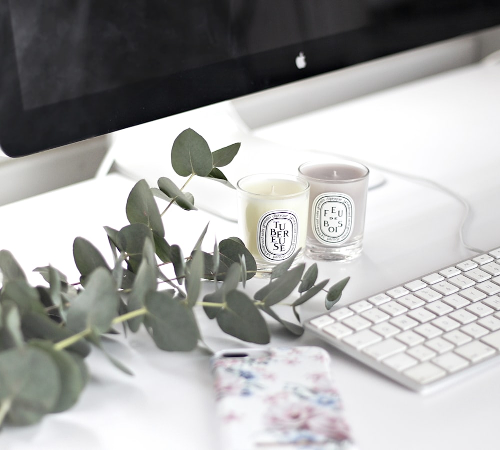 white and black ceramic mug beside white apple keyboard