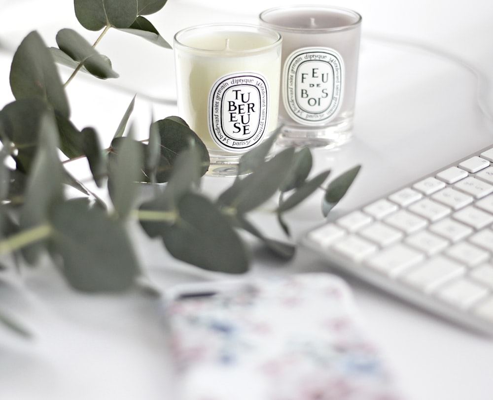 white and black ceramic mug beside white computer keyboard