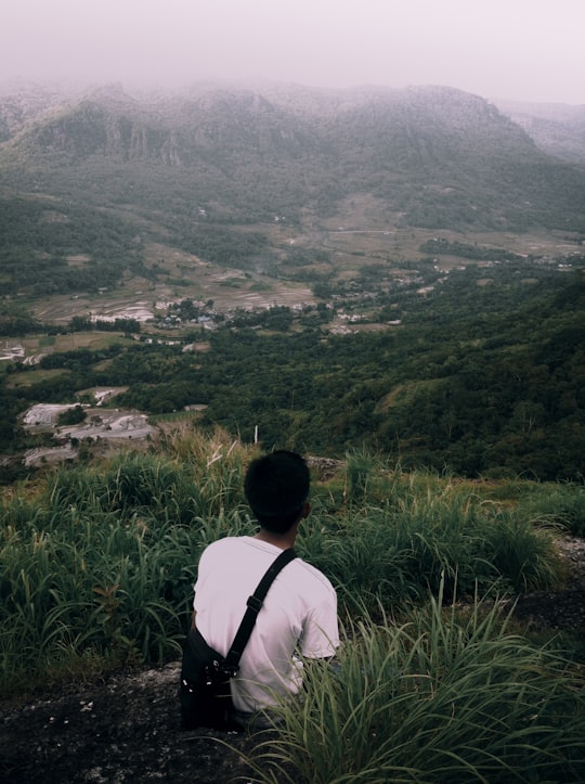 man in white shirt standing on green grass field during daytime in Sulawesi Selatan Indonesia