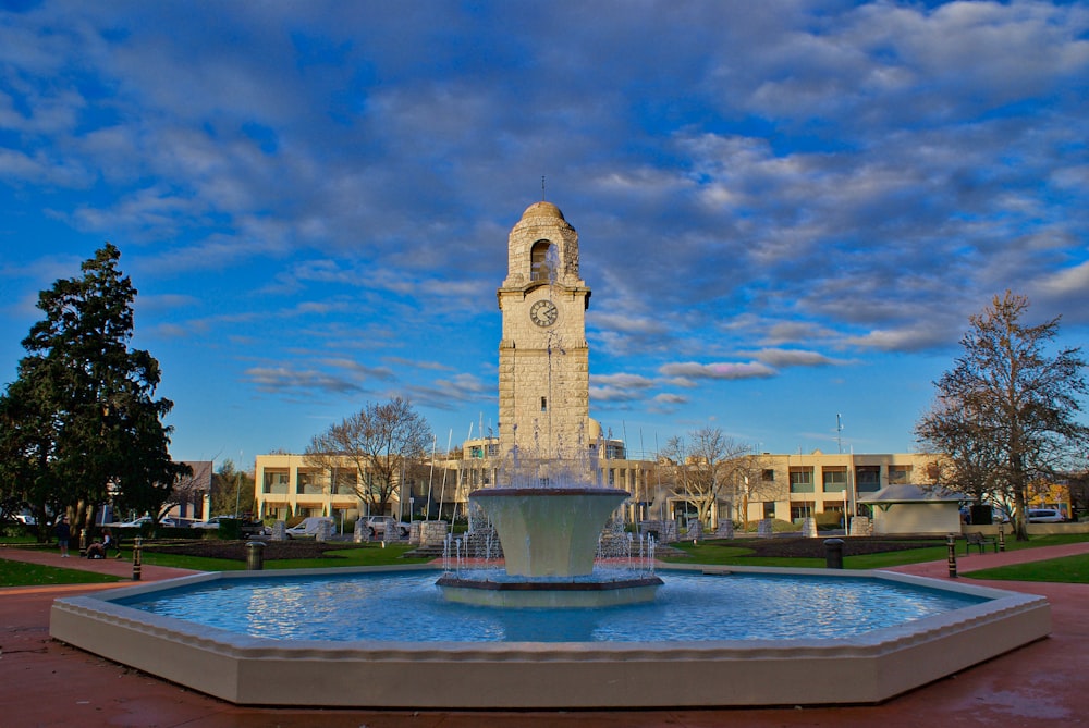 brown concrete building with fountain under blue sky during daytime