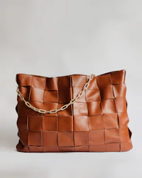 brown leather handbag on white surface