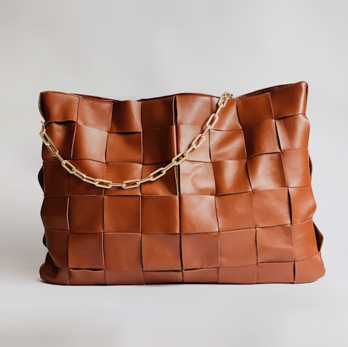 brown leather handbag on white surface