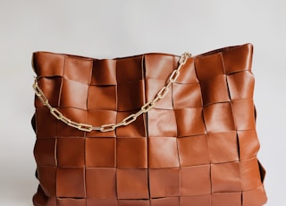 brown leather handbag on white surface