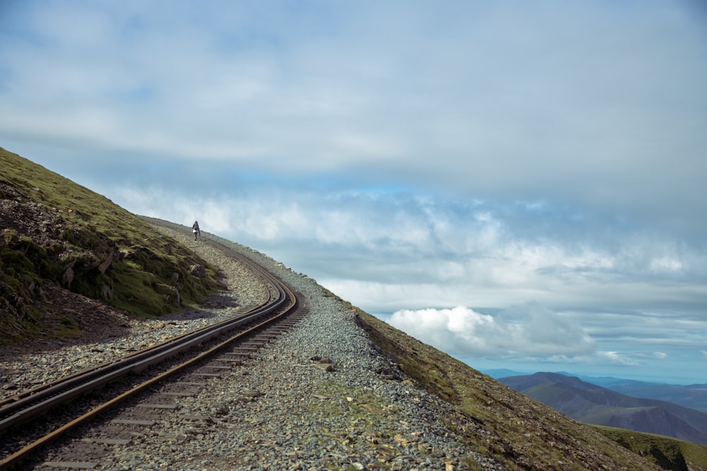 black asphalt road on hill under white clouds during daytime