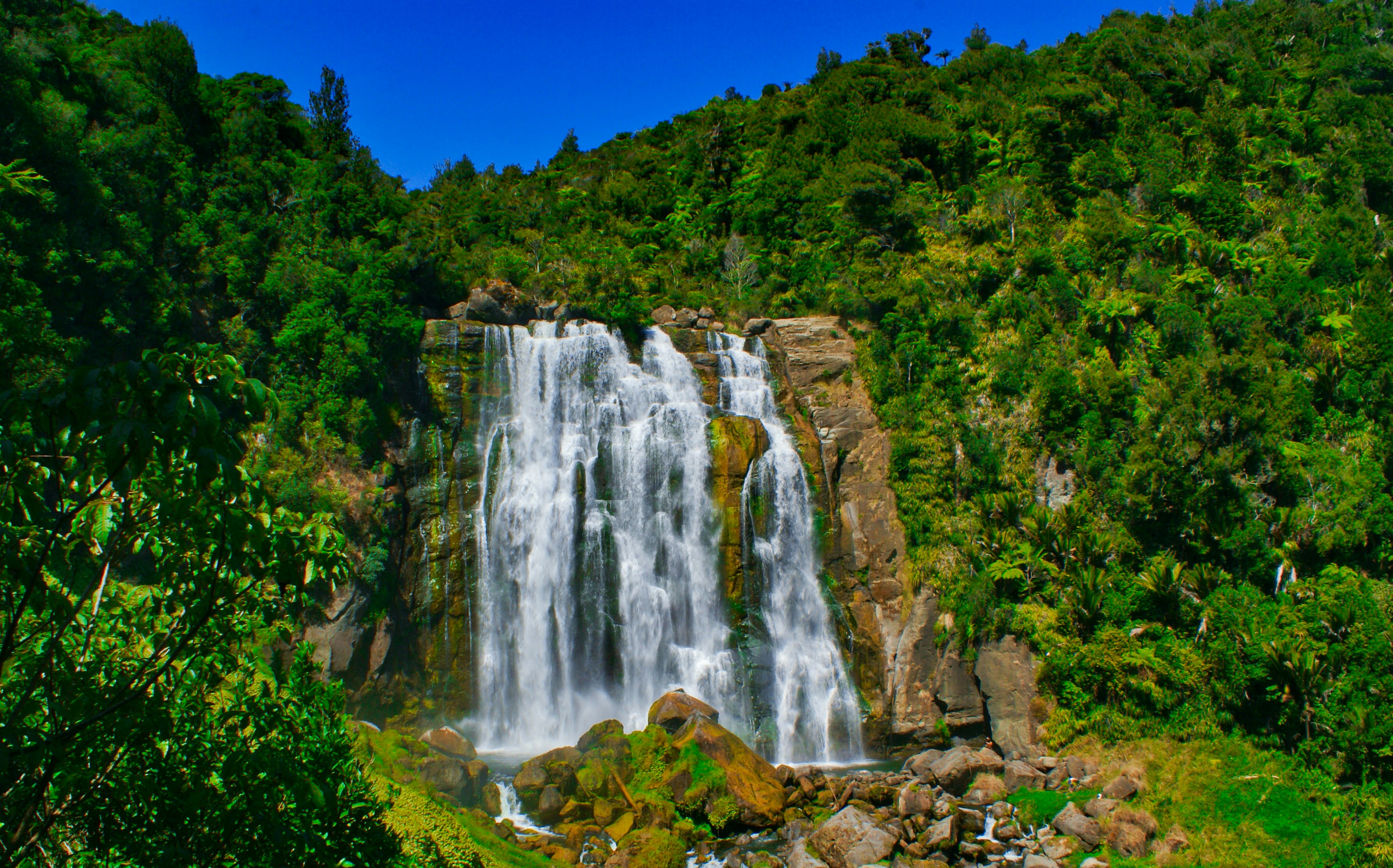 waterfalls in the middle of the forest during daytime, 
