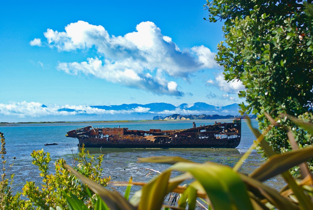 navio marrom no mar sob o céu azul e nuvens brancas durante o dia