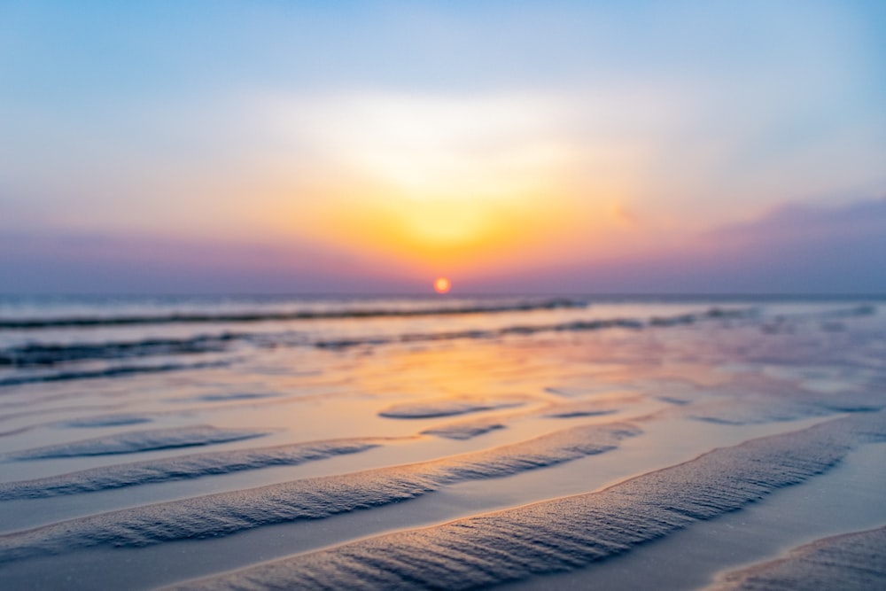 sea waves crashing on shore during sunset