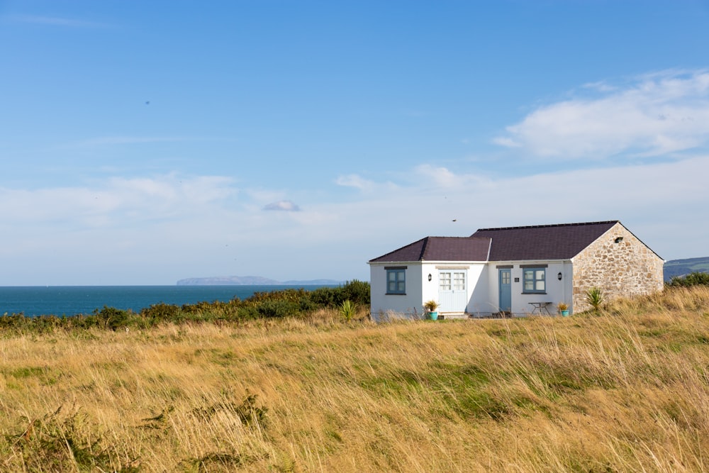 white and gray house on green grass field under blue sky during daytime