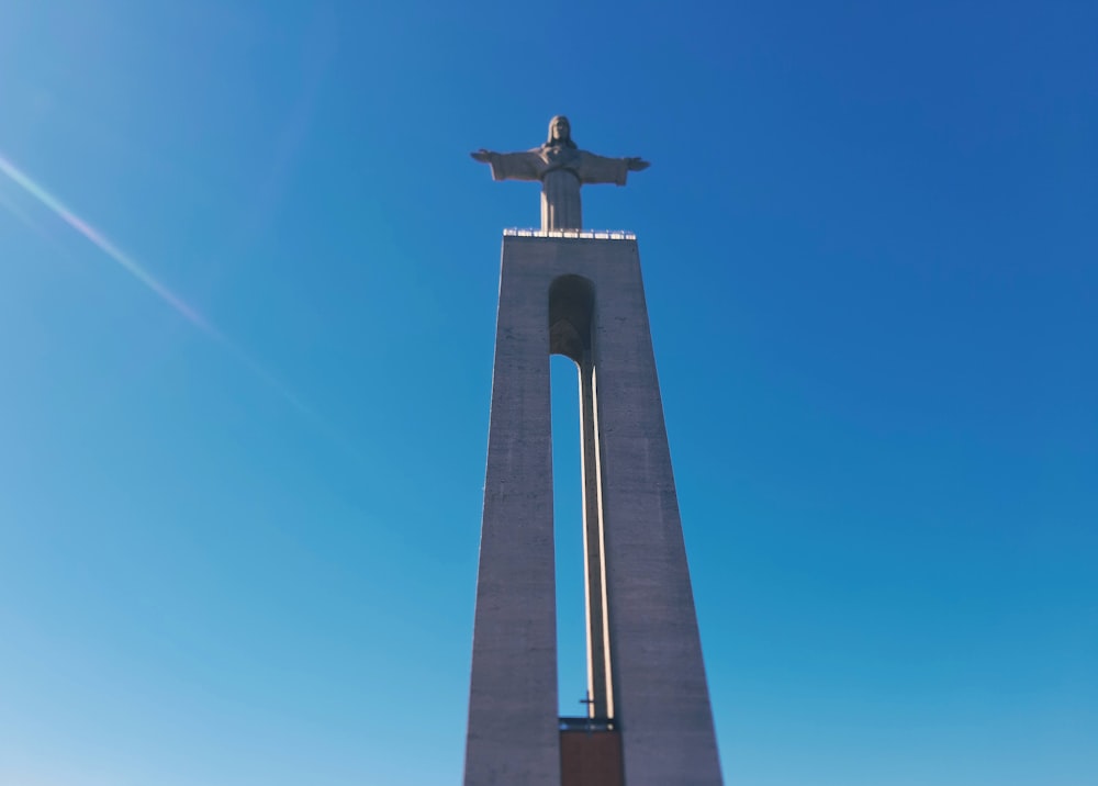 gray concrete cross under blue sky during daytime