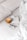 A cozy setting with a neatly made bed featuring a soft white comforter and pillows. On the bed, there is a stack of white paper with a minimalist green design on it, accompanied by a pair of tortoiseshell glasses. A warm brown ceramic mug is also placed beside the papers.