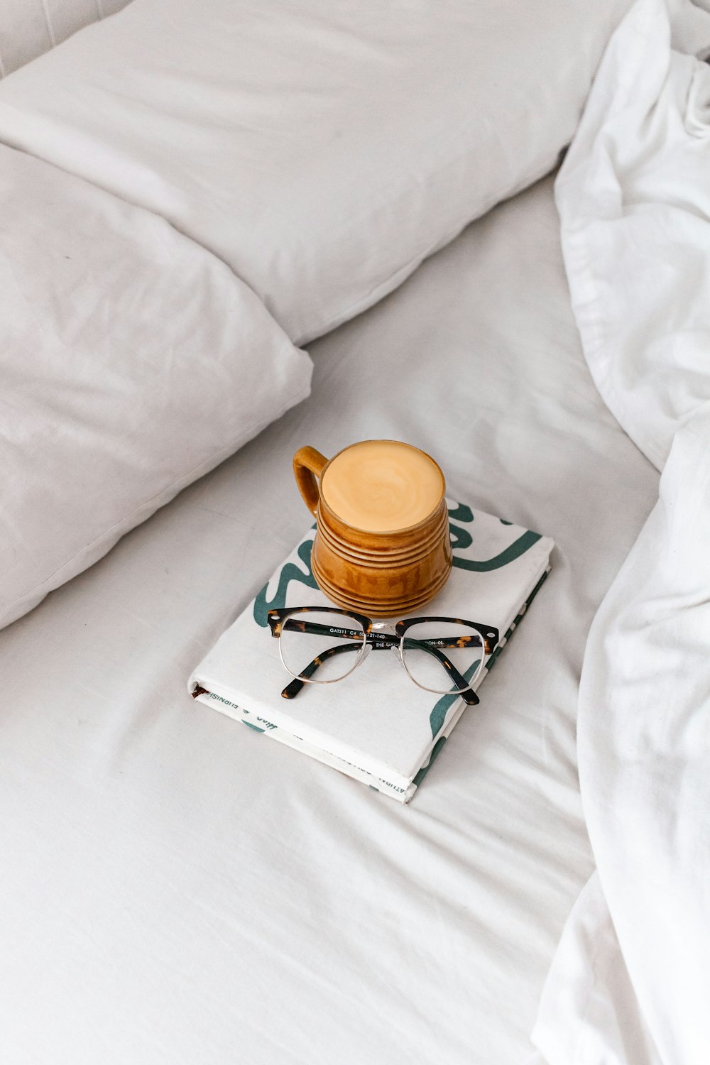 brown ceramic mug on white textile