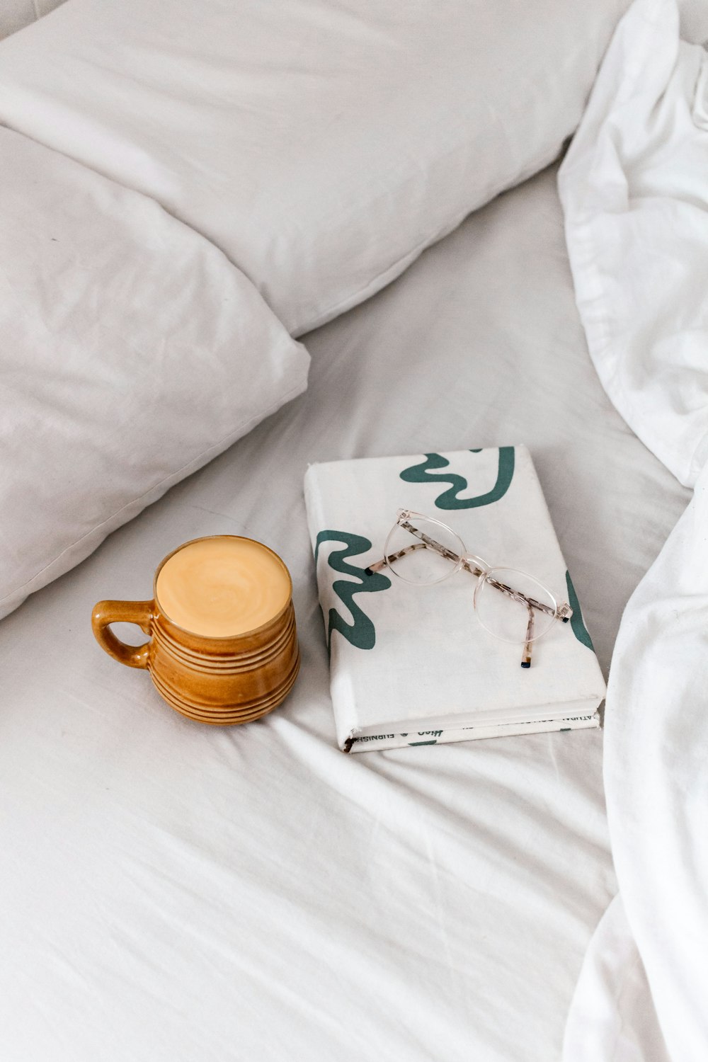 brown ceramic mug on white textile